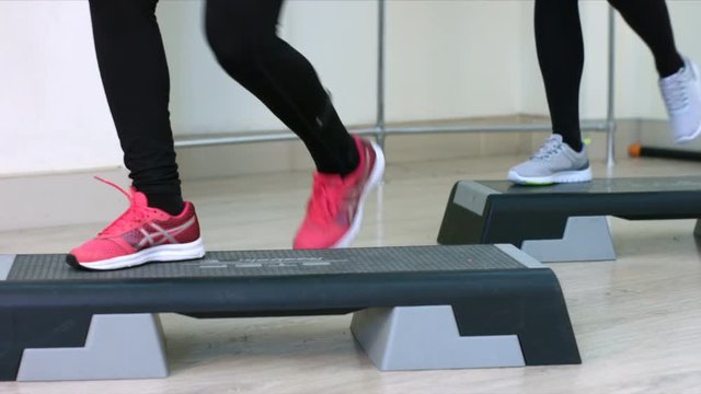 Step Aerobic girl. Foots. Slow motion. Young women in an aerobics class
