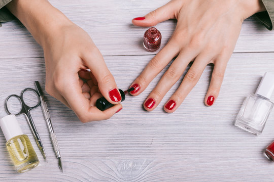 Close-up Of A Woman Paints Her Nails With Red Lacquer