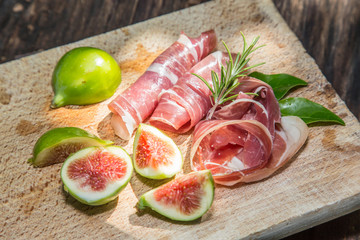 Ripe fig fruits and bacon or prosciutto. Food to accompany the d