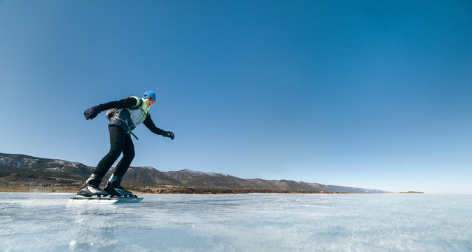 Tourists travel to Norway hiking ice skating on the frozen lake. Special long skate for long distances. Mounting under the ski boots. Location of Lake Baikal action. The Russian called Bayes or Loft.