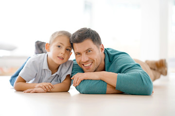 Portrait of daddy and son laying on floor