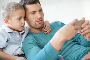 Daddy with son playing with smartphone