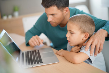 Daddy with kid using laptop computer for e-learning © goodluz