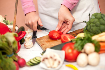 Woman slicing tomato in the kitchen