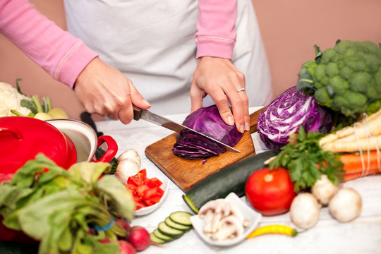 Woman in the kitchen slicing red cabbage