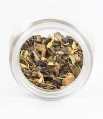 Isolated leaves of tea with flower petals and dehydrated fruits.
