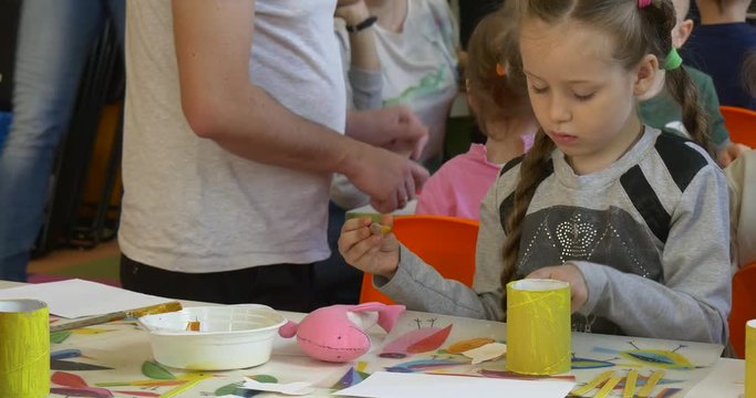 the Girl at the Desk Drawing With a Brush.