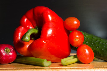 composition red bell pepper, celery, and tomatoes and cucumber on a cutting Board. ingredients for vegetable salad