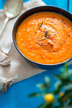 Pumpkin, Tomato, Red Grilled Pepper and Carrot Soup on Blue Wooden Background, Vertical Top View