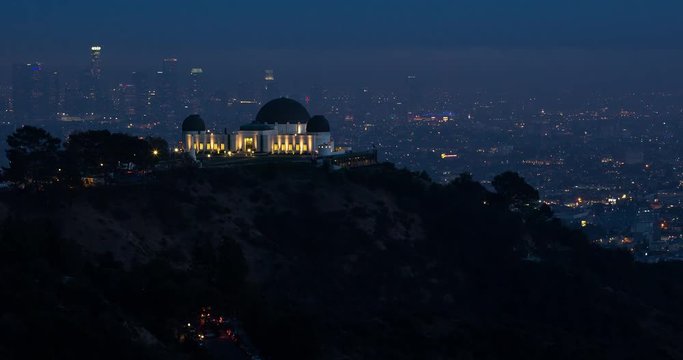 Los Angeles, California, USA - view of illuminated Griffith Observatory and City of Los Angeles facing south at sunset - Timelapse with pan left to right 