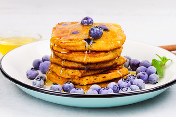 Pumpkin pancakes with blueberries, honey and cinnamon. Butternut squash cakes or fritters. Healthy breakfast, snack or take-away bites