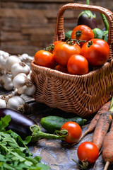 Harvest Vegetables: tomatoes, cucumbers, zucchini, eggplant, onion, garlic, arugula on the wooden background