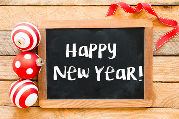 Christmas decoration with happy new year on blackboard over wooden background © roobcio