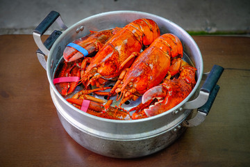 Close up of Maine Lobster in the iron steamer on a dark wooden table