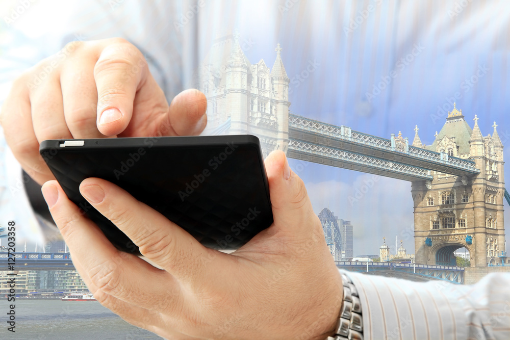 Poster Close up of man using smartphone on London Tower Bridge background 