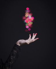 Elegant woman's hand with bright nail Polish and magical glow.