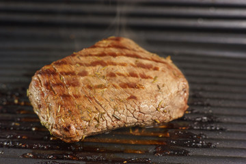 Roasting a steak from beef on grill