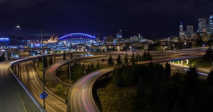 Seattle, Washington, USA - illuminated skyline with CenturyLink Field and Safeco Field as seen from Dr. Jose Rizal Park with Interstate 5 at night - Timelapse with motion and zoom in