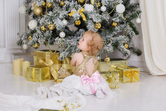 Baby girl near luxury decorated christmas tree