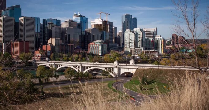 Calgary, Alberta, Canada - view at Commercial Downtown and Centre Street Bridge from Samis Road NE over Bow River at a sunny day - Timelapse with motion and zoom out 