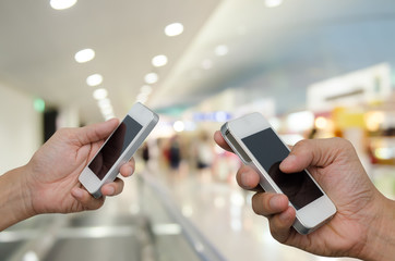Two men holding mobile smart phone.