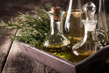 Assortment of spicy sunflower,corn,sesame seeds ,avocado ,grape seeds oils with herbs and spices in different bottles on wooden background