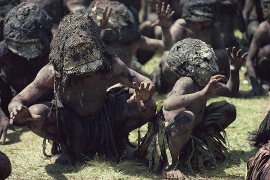 Mud men wearing clay masks perform ritual dance, Asaro Valley, Papua New Guinea Islands