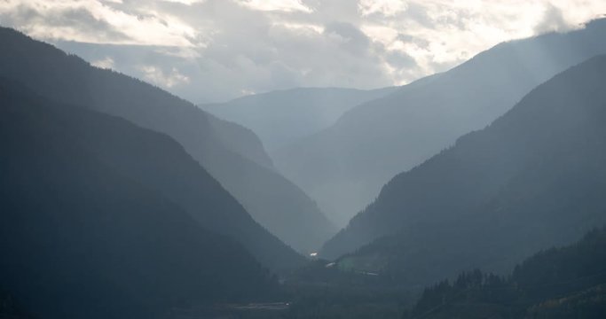 Mount Revelstoke National Park, British Columbia, Canada - view from Mount Revelstoke NP into the valley of Trans-Canada-Highway with sunbeams - Timelapse with pan right to left 