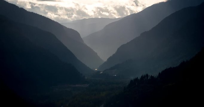 Mount Revelstoke National Park, British Columbia, Canada - view from Mount Revelstoke NP into the valley of Trans-Canada-Highway with clouds and sunbeams - Timelapse with zoom out 