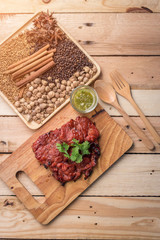 grilled meat, sprig of rosemary and red hot pepper on a wooden l