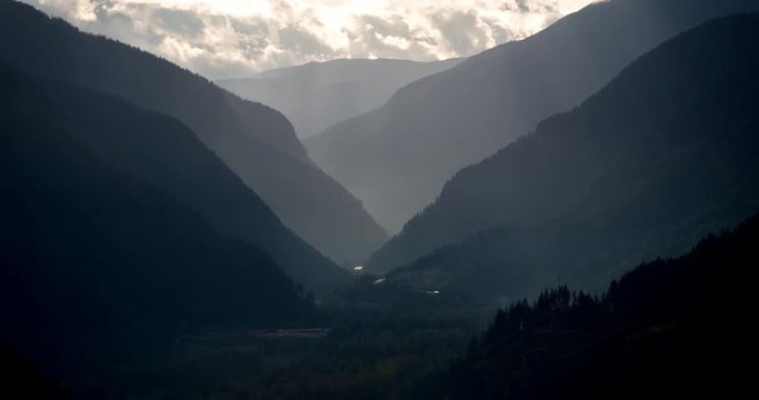 Mount Revelstoke National Park, British Columbia, Canada - view from Mount Revelstoke NP into the valley of Trans-Canada-Highway with sunbeams - Timelapse with pan left to right 