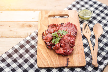 grilled meat, sprig of rosemary and red hot pepper on a wooden l