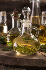 Assortment of spicy sunflower,corn,sesame seeds ,avocado ,grape seeds oils with herbs and spices in different bottles on wooden background