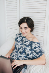 Fototapeta premium Girl looking at the laptop on the bed