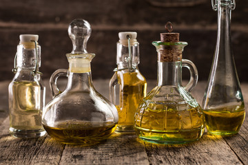 Assortment of spicy sunflower,corn,sesame seeds ,avocado ,grape seeds oils with herbs and spices in different bottles on wooden background