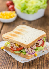 Wooden table with a Tuna Sandwich (selective focus)