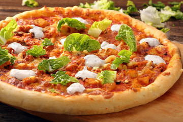 Fresh homemade pizza with chicken and garlic sauce on wooden bac