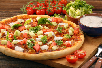 Fresh homemade pizza with chicken and garlic sauce on wooden bac