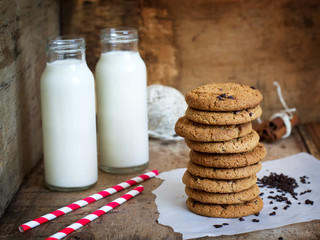 Homemade oatmeal cookies with chocolate and a bottle of milk