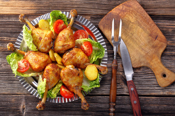 Chicken legs and baked potatoes with vegetable