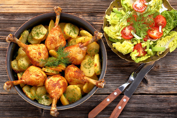 Chicken legs and baked dill potatoes with vegetable salad