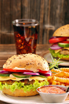 Fresh Tasty Burger With Fries And Drink On Wooden Table