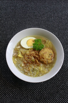 Soto Ayam or Chicken Soto.. One most popular food in Indonesia.. Many province have this Soto Ayam.. And this one is from Madura - East Java.. Top View with soup and black background.