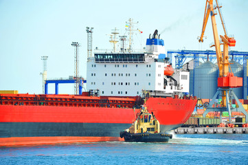 Tugboat assisting bulk cargo ship