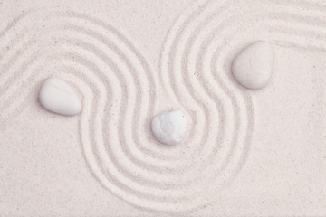 Zen garden with white marble rocks and wave pattern in the white sand