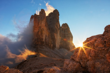 Mist, verlicht door de zon bij zonsondergang tussen de rotsen de Cime di Lavaredo de Tre, Dolomieten, Italië