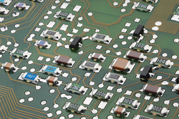 Surface-mount components on electronic circuit board close-up.