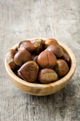 Chestnuts in a bowl on wooden background
