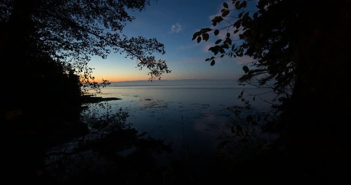Tongue Point, Washington, USA - sunset with orange sky above a bay of the oceans at the Tongue Point - Timelapse with pan right to left 