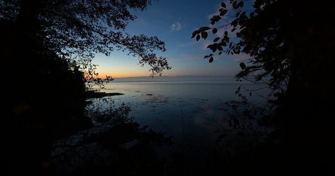 Tongue Point, Washington, USA - sunset with orange sky above a bay of the oceans at the Tongue Point - Timelapse with pan left to right
